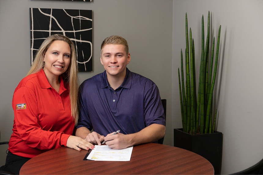 Rush Truck Leasing employee sitting next to customer signing document