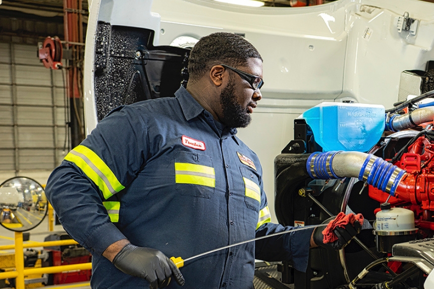 Technician checking truck's dipstick